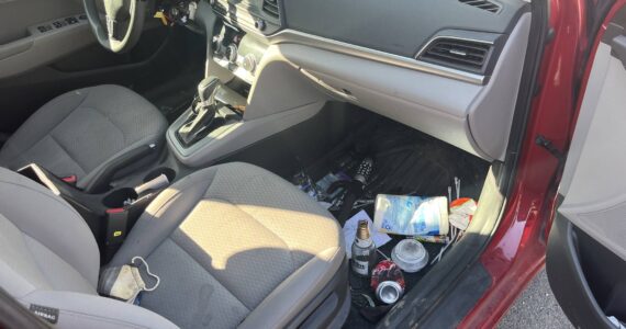 A glass of beer, a joint, a box of unopened condoms and a steering wheel lock on the floor of Doug Lindquist’s 2019 Hyundai Elantra. (Photo by Ben Leung/Renton Reporter)