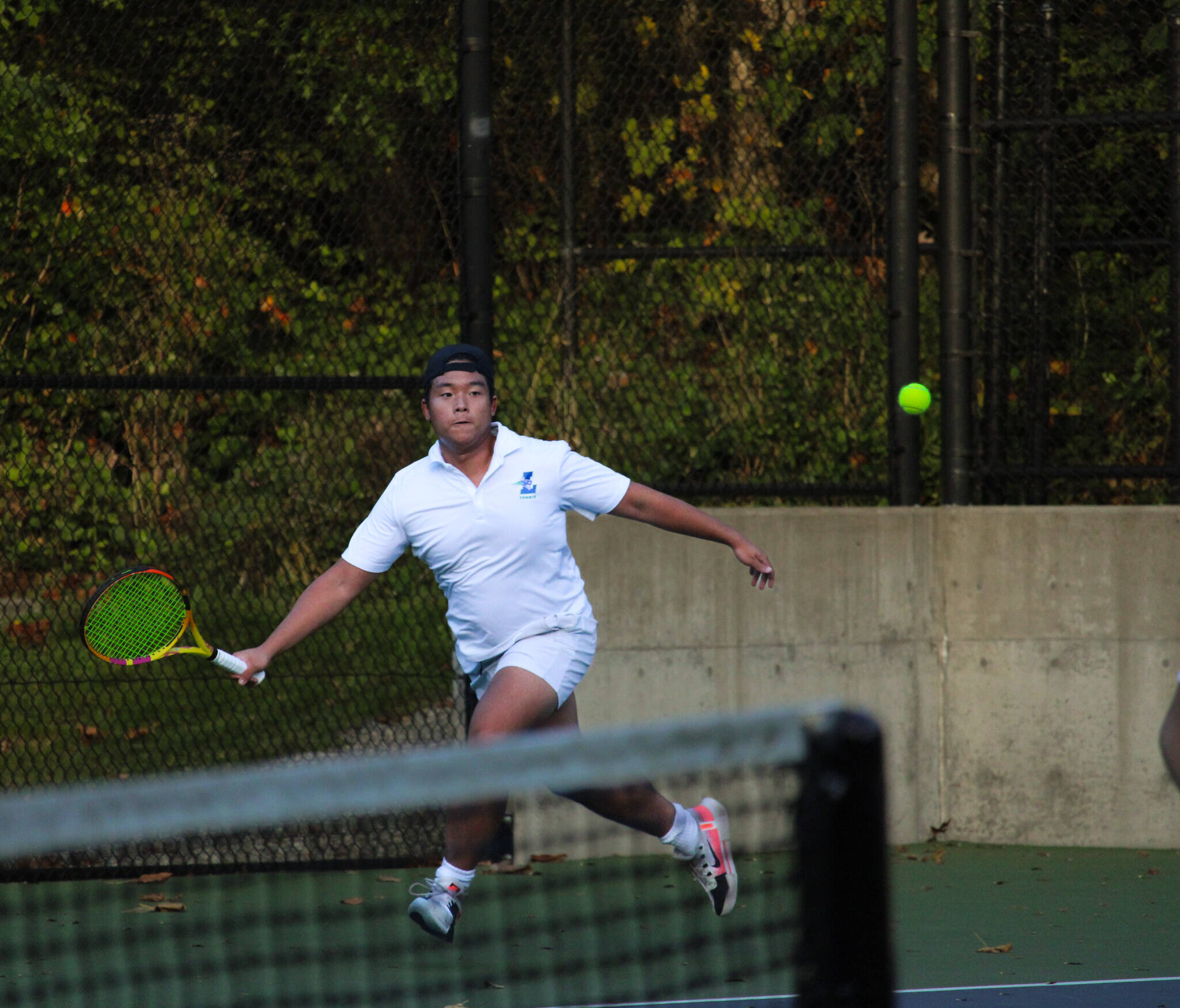 Liberty senior Alex Tran looks to return a volley in his tightly contested doubles match. Photo taken by Alexis Phung