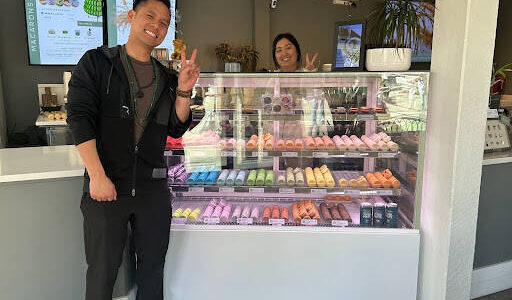 Picture of business owner Michael Huynh, employee Jemmy and a display of macarons. Photo by Janiyah Gibson/The Reporter