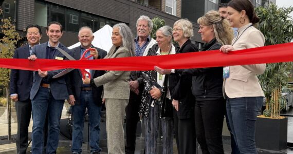 Renton City Councilmember Ruth Pérez cuts the ribbon celebrating the opening of Astra and Solera along with other councilmembers and other leaders instrumental in the opening of the apartments. Photo by Drew Dotson/Renton Reporter